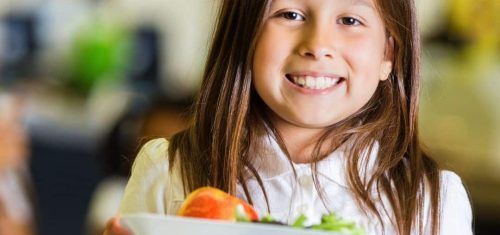 Smiling girl holding school lunch tray
